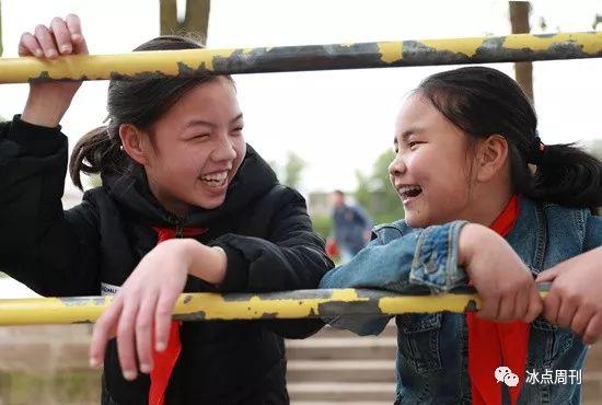 2017年3月22日,四川省华蓥市禄市小学的两名留守儿童,在课余时间聚在一起开心地交流。(资料图片)视觉中国供图