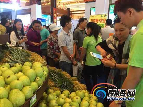 2015海南冬交会上，市民现场花一分钱购买水果。