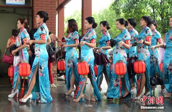 中国多地女性同秀旗袍挑战“世界吉尼斯旗袍秀”纪录