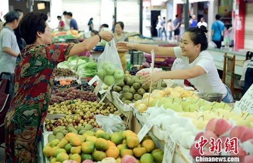 资料图：民众正在购买水果。中新社记者 刘忠俊 摄