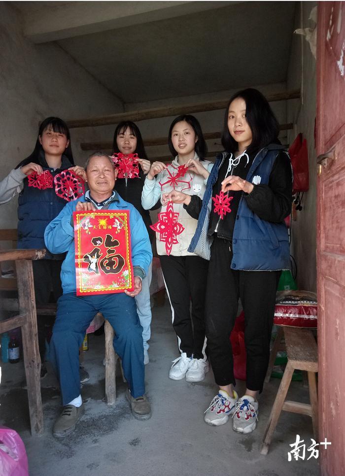 图为韩师的学生志愿者在梅州五华，与麻风病患者展示剪纸作品。